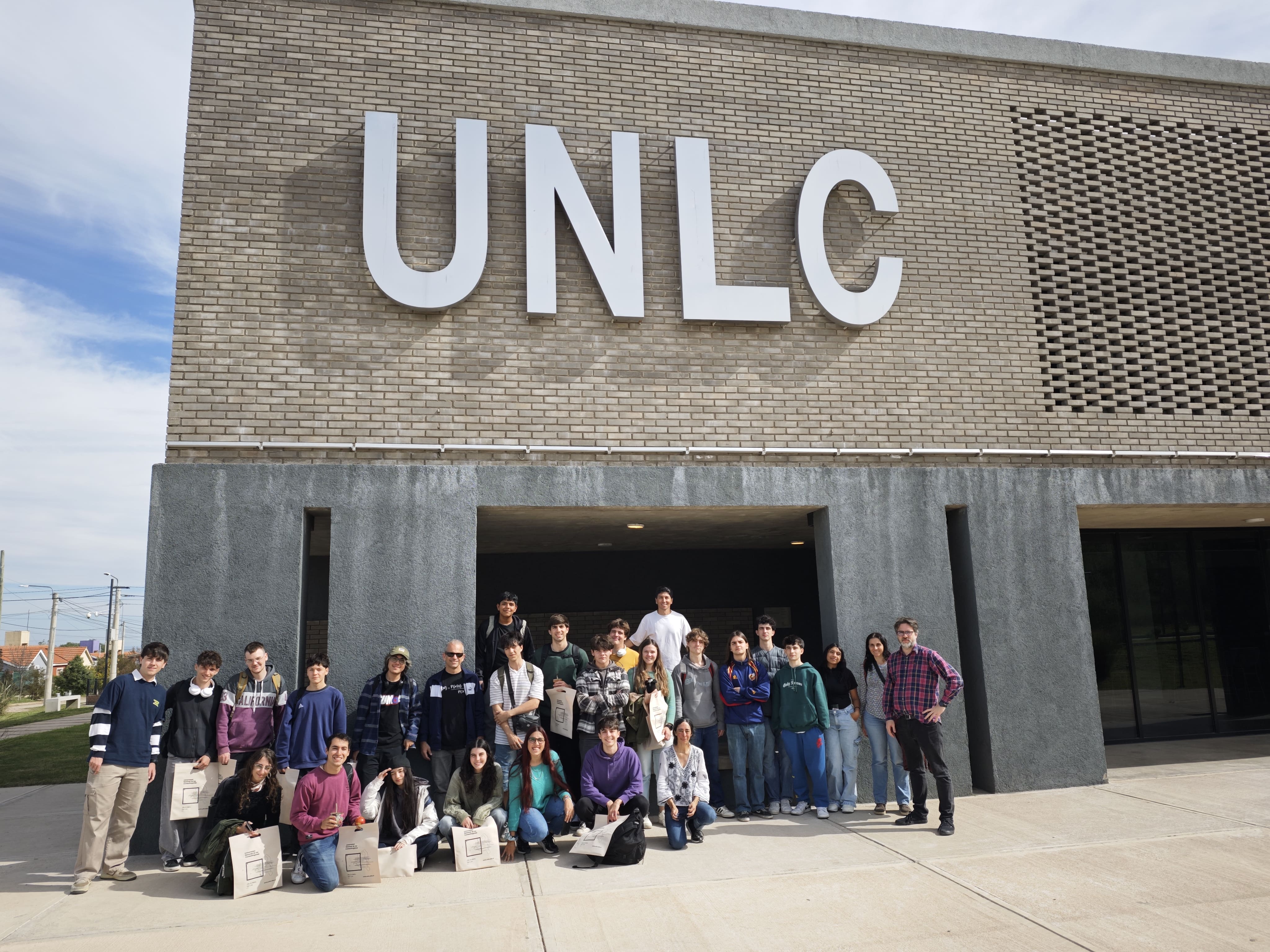 Foto del grupo con vista del edificio principal de la UNLC en Merlo
